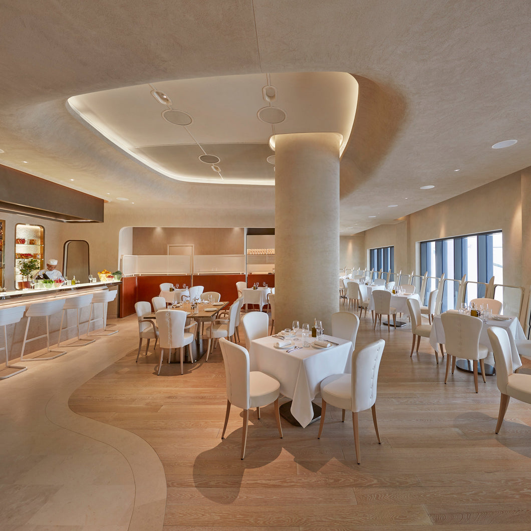 IZU restaurant interior first floor with tables, chairs, and a kitchen area.