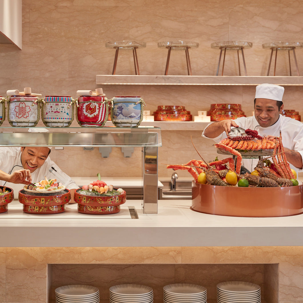 Chefs preparing food in a modern kitchen with decorative elements.